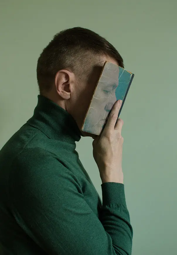 Hombre sosteniendo un retrato frente a su rostro