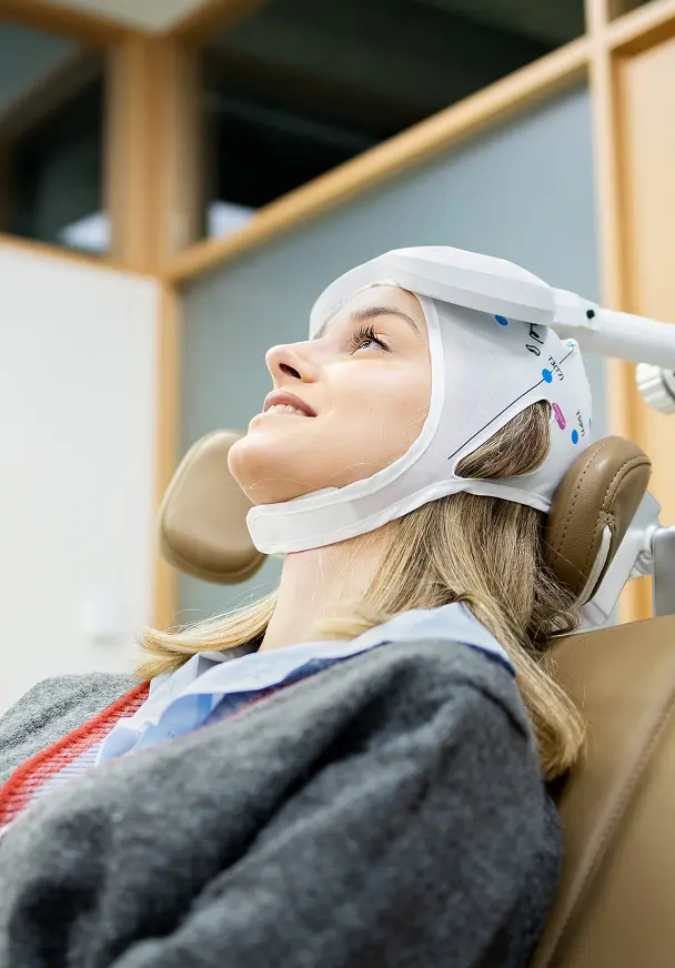 Paciente recibiendo una sesión de Deep TMS en un consultorio clínico