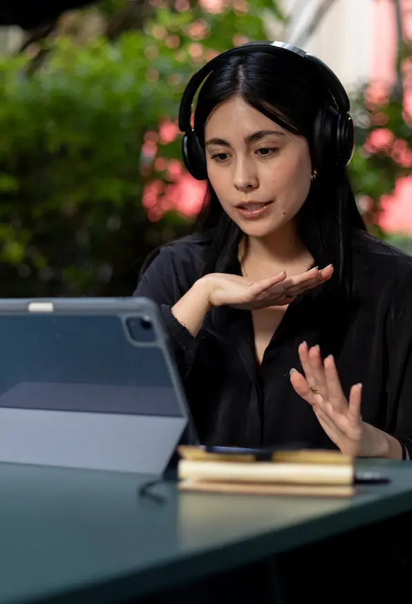 Recepcionista con auriculares atiende una consulta por videollamada